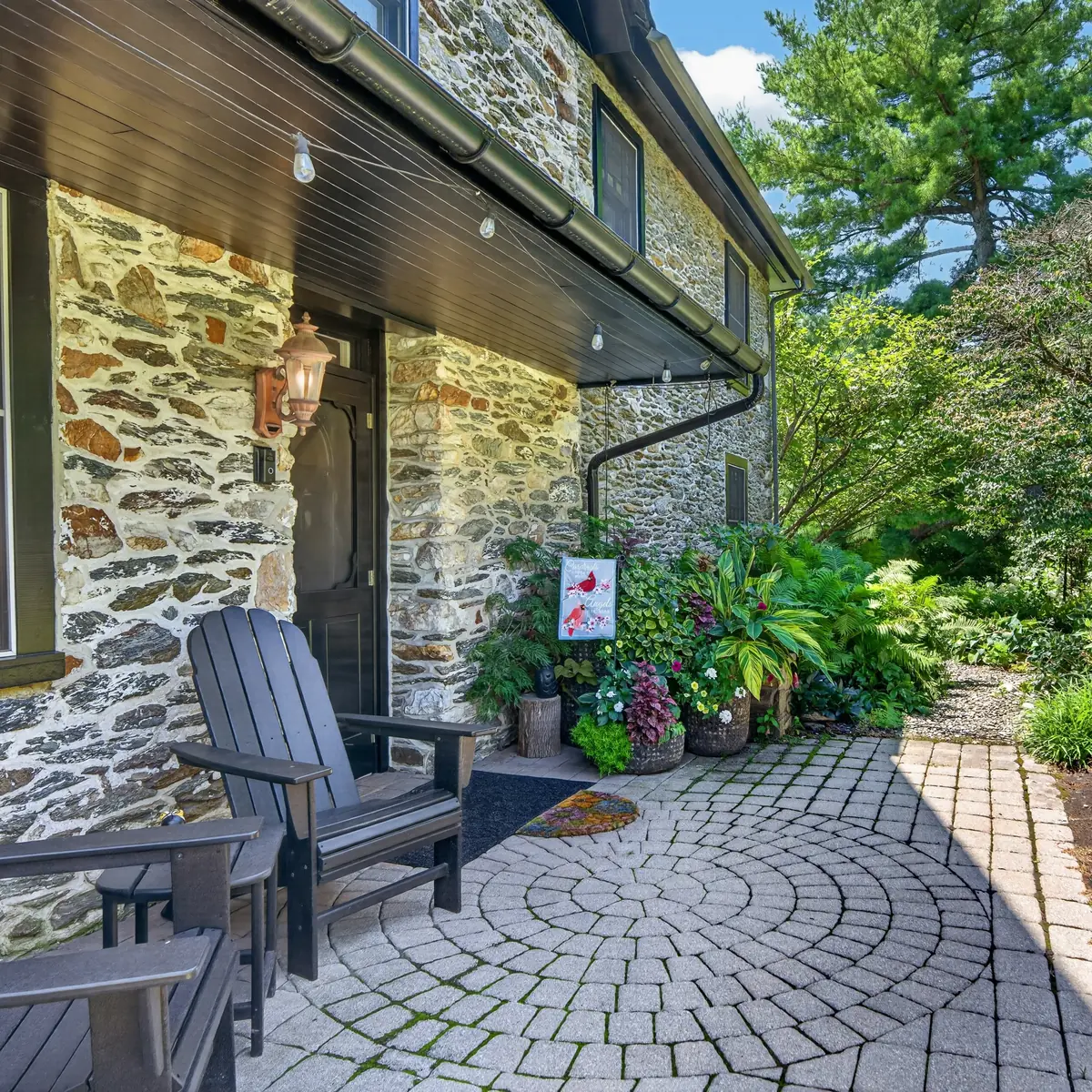 Stone entry patio with Adirondack seating