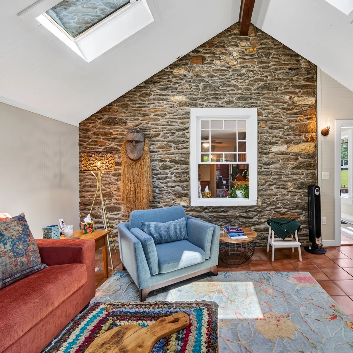Den with original fieldstone wall and vaulted skylit ceiling